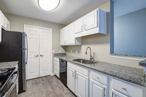 Martinez apartment for rent - A kitchen with white cabinets and a black refrigerator.