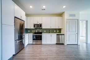 Prospect apartment for rent - A kitchen with white cabinets and a wooden floor.