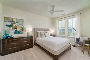 Prospect apartment for rent - a bedroom with a bed and a dresser and a ceiling fan at Lyric at Norton Commons Apartments, Prospect, Kentucky