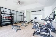 Chattanooga apartment for rent - A spacious home gym with a variety of equipment including a stationary bike, a rowing machine, and a weight rack.