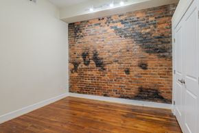 Petersburg apartment for rent - A room with a brick wall and wooden floor.