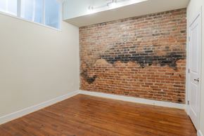 Petersburg apartment for rent - A room with a brick wall and wooden floor at Mayton Transfer Lofts in Virginia 23803