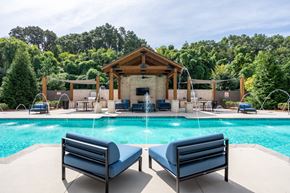 Chattanooga apartment for rent - A pool with a wooden pavilion and lounge chairs.