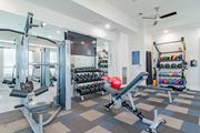 Newnan apartment for rent - A gym with a variety of equipment including a leg press machine.