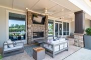 Newnan apartment for rent - A modern living room with a stone fireplace and a flat screen TV mounted above it.