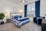 Acworth apartment for rent - a bedroom with a bed and a chair and a ceiling fan at The Quincy Apartments, Acworth, Georgia