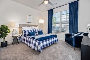 Acworth apartment for rent - a bedroom with a bed and a chair and a ceiling fan at The Quincy Apartments, Acworth, Georgia