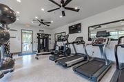 Gainesville apartment for rent - A spacious gym with treadmills, elliptical machines, and a ceiling fan.