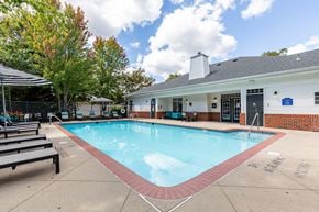 Gainesville apartment for rent - A small pool in front of a building with a blue sign.