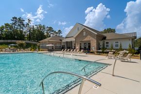 Arden apartment for rent - A large swimming pool in front of a building with a sunny sky.