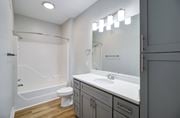 Virginia Beach apartment for rent - A white bathroom with a toilet, sink, and mirror.