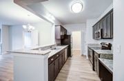 Virginia Beach apartment for rent - A kitchen with white and brown cabinets and a marble countertop.