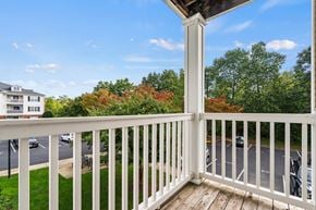 Gainesville apartment for rent - a balcony with a view of a parking lot and trees at SomerHill Farms Apartments, Gainesville, VA