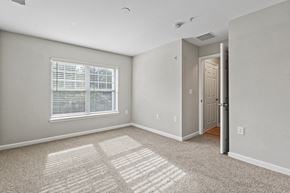 Gainesville apartment for rent - an empty bedroom with a large window and carpet at SomerHill Farms Apartments, Gainesville, VA 20155