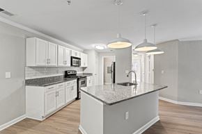 Gainesville apartment for rent - a kitchen with white cabinets and a marble counter top at SomerHill Farms Apartments, Gainesville, VA 20155