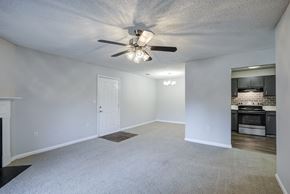 Warner Robins apartment for rent - A spacious room with a ceiling fan and a fireplace at Southland Station Apartments in Warner Robins, 31088