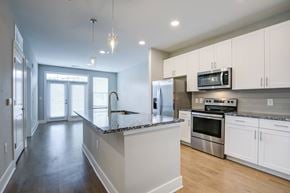 Lawrenceville apartment for rent - A kitchen with white cabinets and a granite countertop.