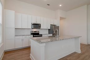 Acworth apartment for rent - A kitchen with white cabinets and a granite countertop.