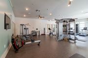 Williamsburg apartment for rent - A spacious gym with a variety of equipment including a treadmill, a bench press, and a squat rack.