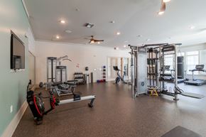 Williamsburg apartment for rent - A spacious gym with a variety of equipment including a treadmill, a bench press, and a squat rack.