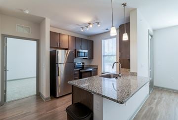 Williamsburg apartment for rent - A kitchen with a granite countertop and stainless steel appliances.