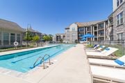 Williamsburg apartment for rent - A swimming pool with sun loungers and apartment buildings in the background.