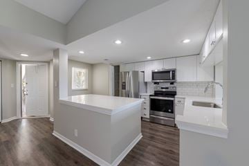 Parkland apartment for rent - A modern kitchen with stainless steel appliances and a breakfast bar.
