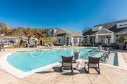 Knoxville apartment for rent - a large swimming pool with chairs and a house in the background at Village at Westland Cove Apartments, Knoxville, 37922