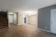 Aiken apartment for rent - A room with wooden floors and a staircase leading to another room.