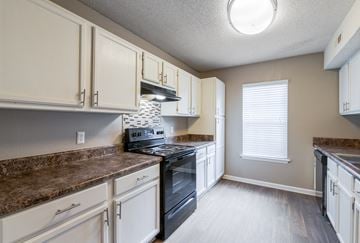 Aiken apartment for rent - A kitchen with a black oven and brown countertops.