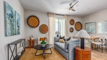 Kissimmee townhouse for rent - A living room with a grey couch, a black table, and a painting on the wall.