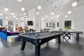 Asheville apartment for rent - A pool table is in the middle of a room with a TV and a bar.