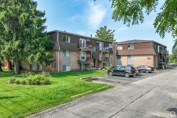 Dekalb apartment for rent - A row of houses with cars parked in front.