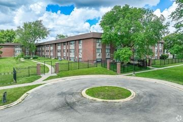 Dekalb apartment for rent - A large building with a circular driveway in front.