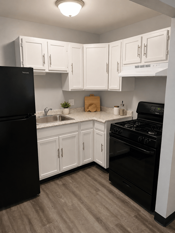 Columbus apartment for rent - A kitchen with black appliances and white cabinets.
