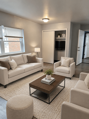 Columbus apartment for rent - A living room with a white sofa, a white chair, a brown coffee table, and a white rug.