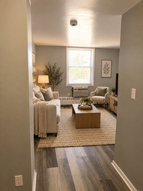 Dekalb apartment for rent - A well-lit living room with a couch, coffee table, and a window.