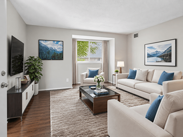 Tuscaloosa apartment for rent - A living room with a white couch, a coffee table, and a painting on the wall.