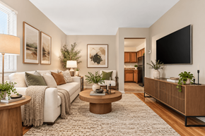 Columbus apartment for rent - A living room with a white couch, a coffee table, and a flat screen TV mounted on the wall.