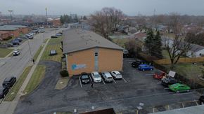 Columbus apartment for rent - A parking lot with cars and a building in the background.