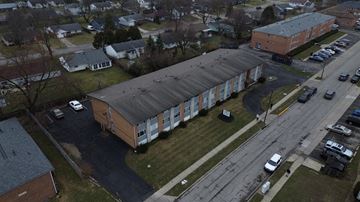 Columbus apartment for rent - A parking lot is in front of a building with a long row of cars parked.