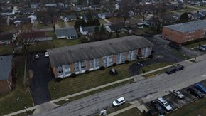 Columbus apartment for rent - A parking lot with cars and a building in the background.
