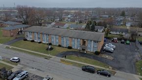 Columbus apartment for rent - A parking lot with cars and a building in the background.