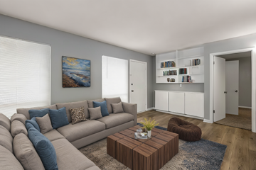 Shreveport apartment for rent - A living room with a grey couch, a brown coffee table, and a painting on the wall.