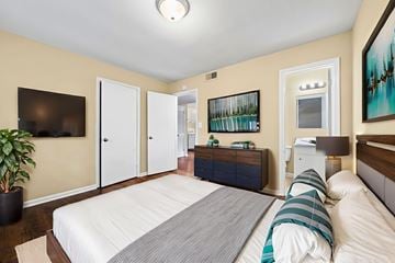 Tuscaloosa apartment for rent - A bedroom with a large bed and a TV on the wall.