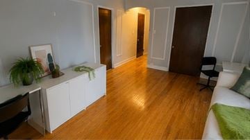 Syracuse apartment for rent - A living room with a white couch and a green pillow.
