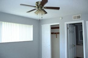 Olivette apartment for rent - a bedroom with a ceiling fan and a door to a bathroom