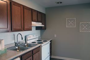 St. Louis apartment for rent - a kitchen with white appliances and wooden cabinets and a sink