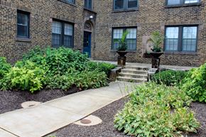 St. Louis apartment for rent - A brick building with a green bush in front.
