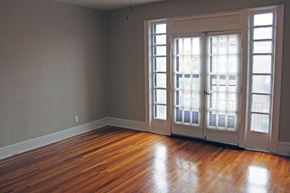 St. Louis apartment for rent - A room with a wooden floor and a large window with blinds.